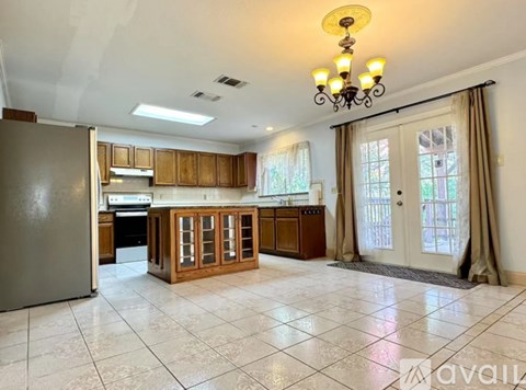 A kitchen with wooden cabinets and a tiled floor.