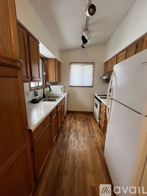 A kitchen with wooden cabinets and a white fridge.
