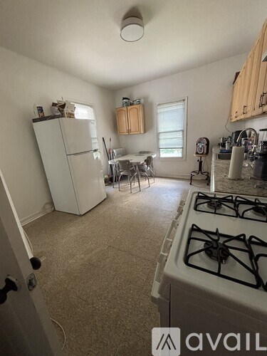 A kitchen with a white gas stove and a white refrigerator.