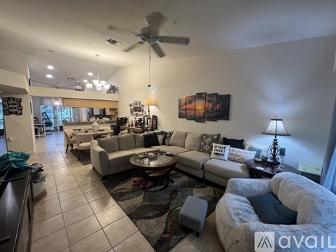 A living room with a large couch and a ceiling fan.