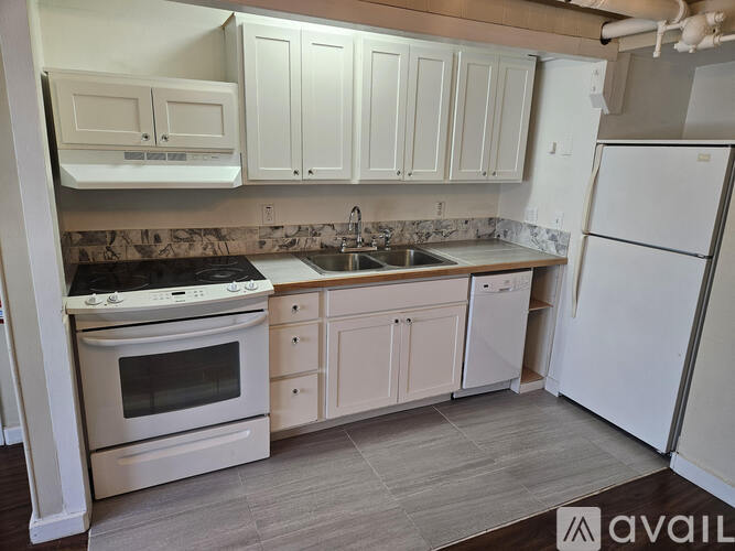 A kitchen with white appliances and cabinets.