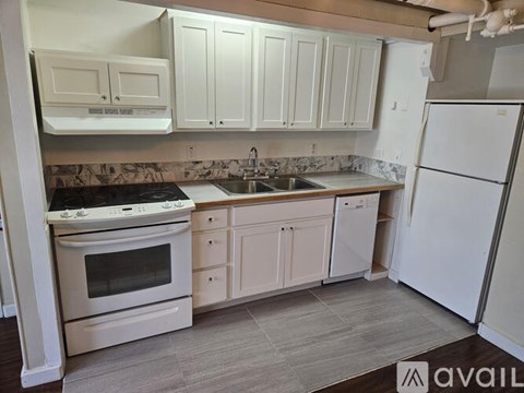 A kitchen with white appliances and cabinets.