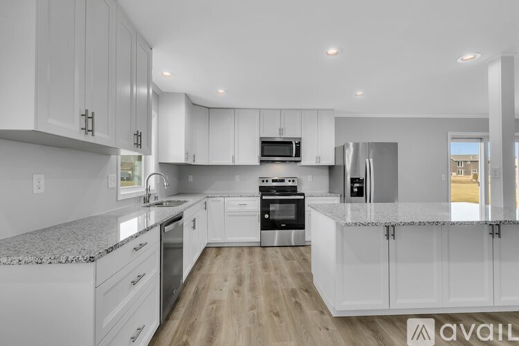 A modern kitchen with white cabinets and stainless steel appliances.