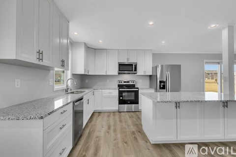 A modern kitchen with white cabinets and stainless steel appliances.