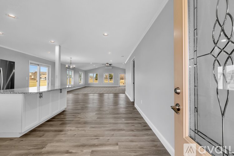 A long, narrow hallway with white walls and wooden floors.