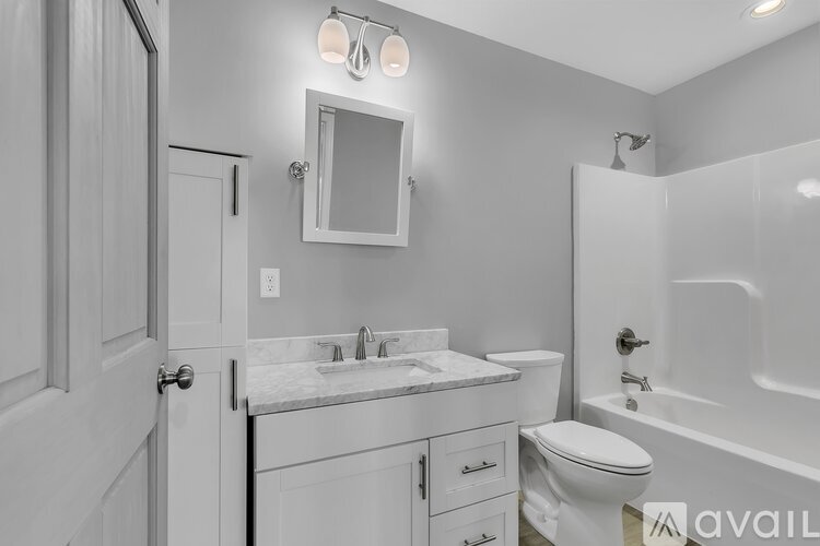 A bathroom with a white toilet, sink, and bathtub.
