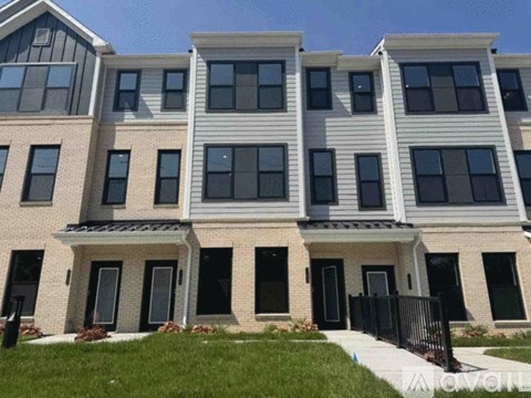 A row of townhouses with black railings and white trim.