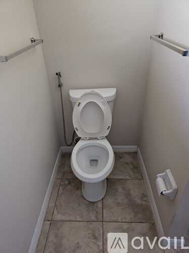 A white toilet in a small bathroom with a tiled floor.
