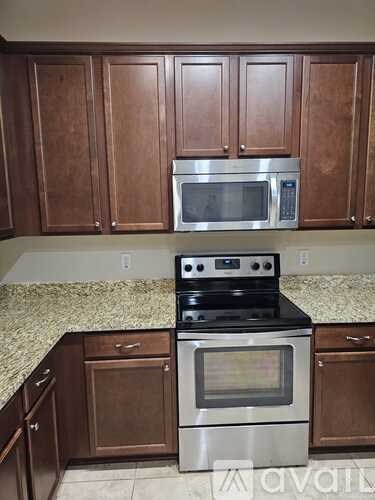 A kitchen with brown cabinets and a stove top oven.