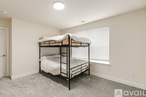 A bedroom with a bunk bed and a window with blinds.