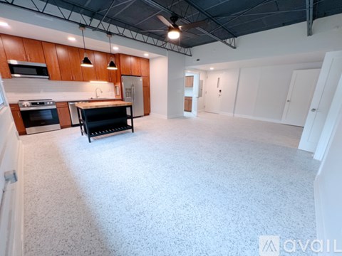 A spacious kitchen with wooden cabinets and a black stove top oven.