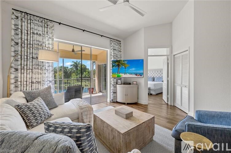 A living room with a large window overlooking a beach.