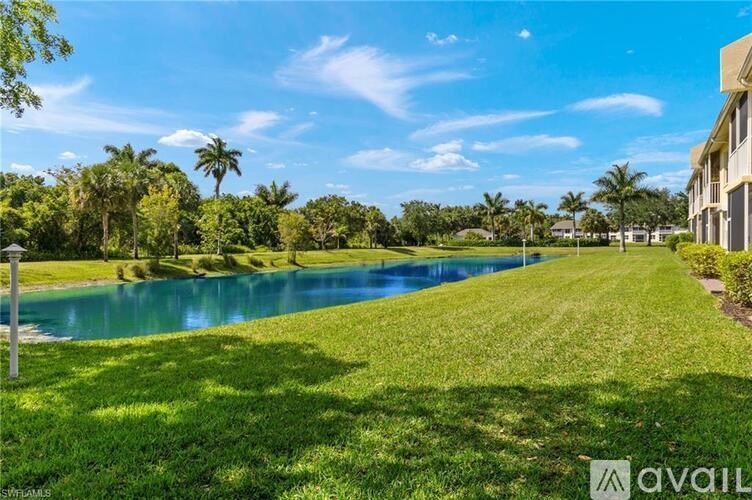 A serene landscape with a body of water, lush greenery, and a clear blue sky.