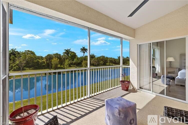 A balcony with a pool and trees in the background.