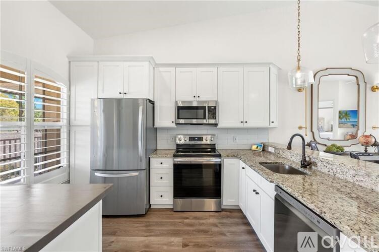 A modern kitchen with a stainless steel refrigerator, microwave, and oven.