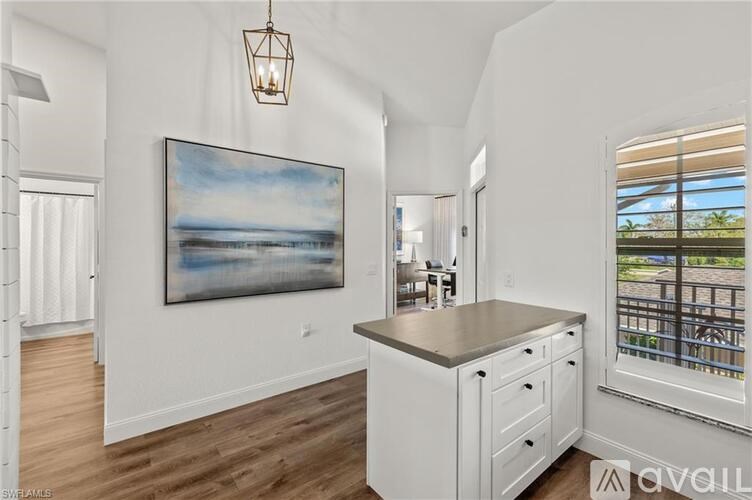 A kitchen with a painting of a beach on the wall.