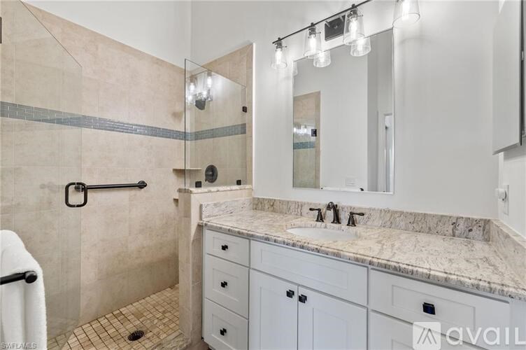 A bathroom with a marble countertop and a walk-in shower.