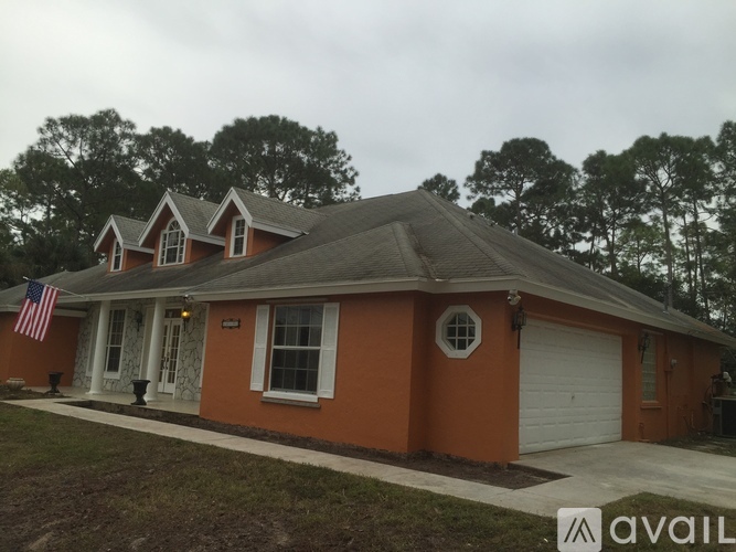 A house with a grey roof and a white garage door.