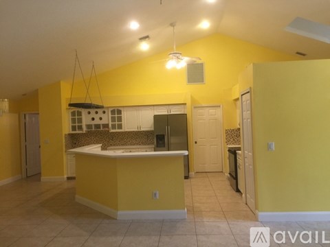 A kitchen with yellow walls and a large island.