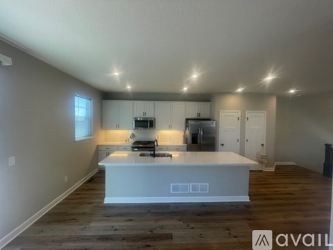 A kitchen with a white island in the middle of the room.