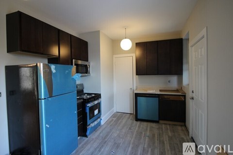 A kitchen with a black refrigerator and wooden cabinets.