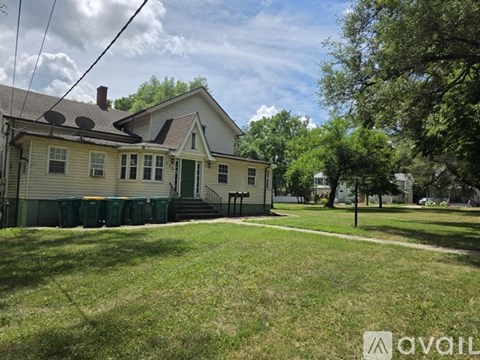 A house with a green lawn in front of it.