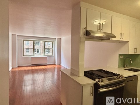 A kitchen with a stove top oven and a window with a view of a city.