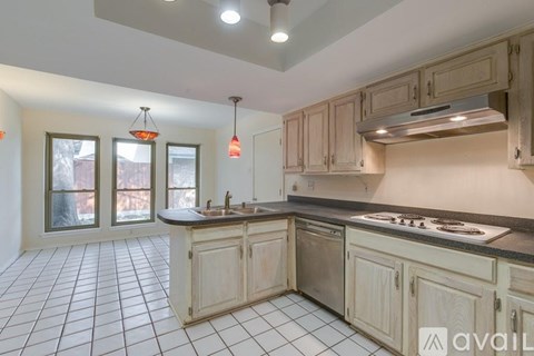 A kitchen with wooden cabinets and a black countertop.