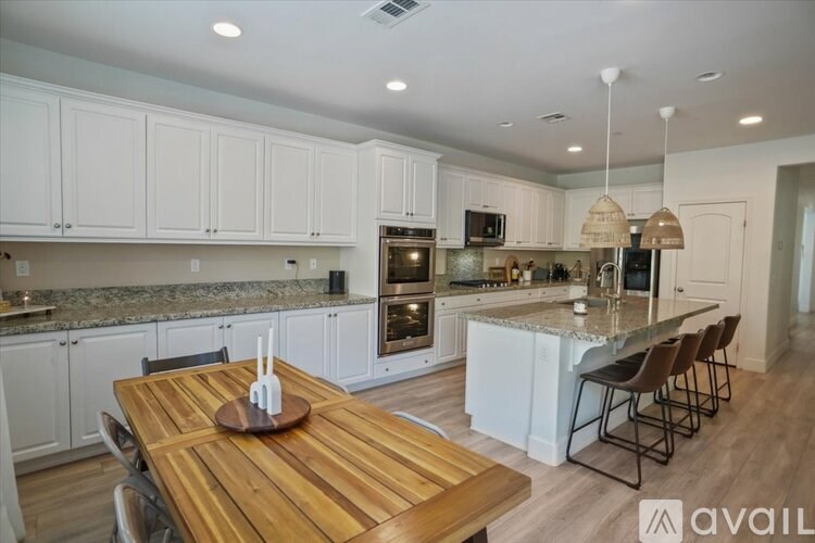 A kitchen with a wooden table and chairs.