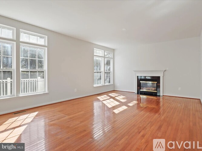 A living room with a fireplace and hardwood floors.