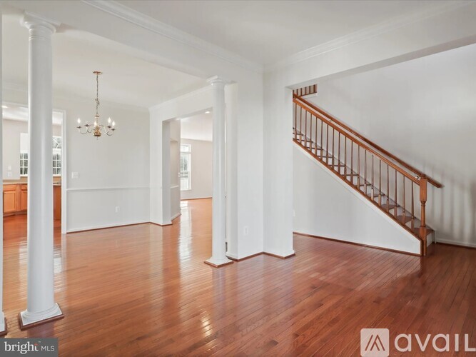A spacious room with a staircase and a chandelier.