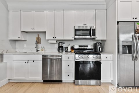 A kitchen with white cabinets and stainless steel appliances.