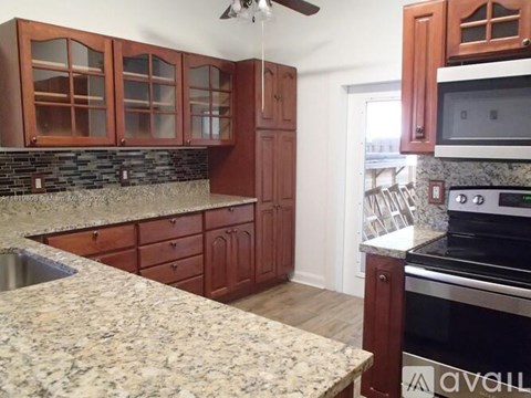 A kitchen with wooden cabinets and granite countertops.