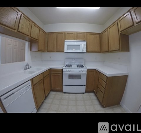 A kitchen with wooden cabinets and white appliances.
