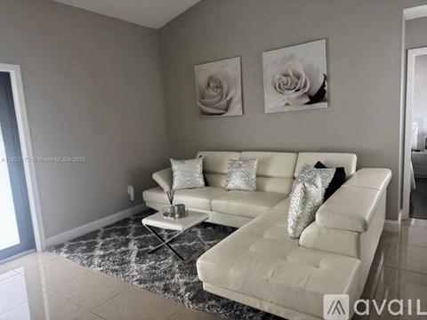 A living room with a white sofa and two pillows.