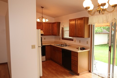 A kitchen with wooden cabinets and a white counter top.