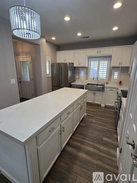A modern kitchen with white cabinets and a large island.