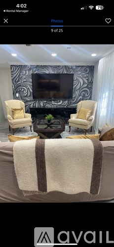 A living room with a television and two chairs.