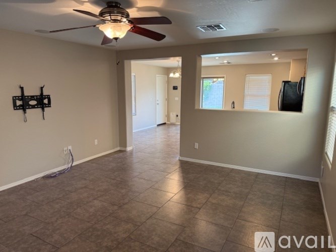 A spacious room with tile flooring and a ceiling fan.