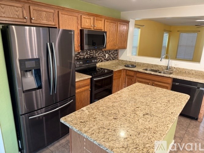 A kitchen with granite countertops and stainless steel appliances.