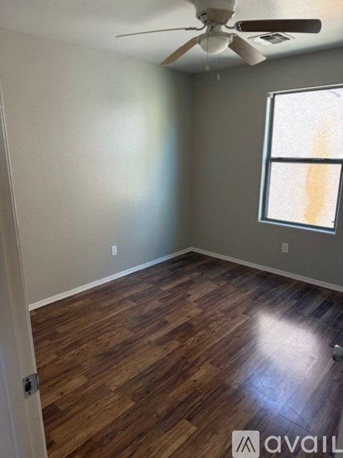A room with wooden flooring and a ceiling fan.