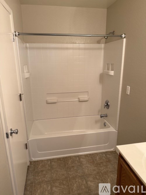 A room with wooden flooring and a window with blinds.