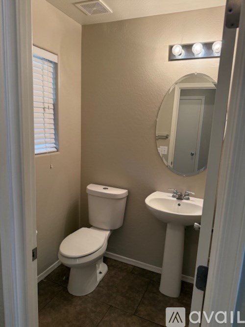 A bathroom with a toilet, sink, and mirror.
