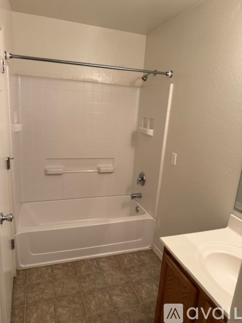 A white bathtub with a shower curtain rod above it.