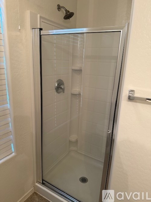 A glass shower stall with a black frame and a silver handle.