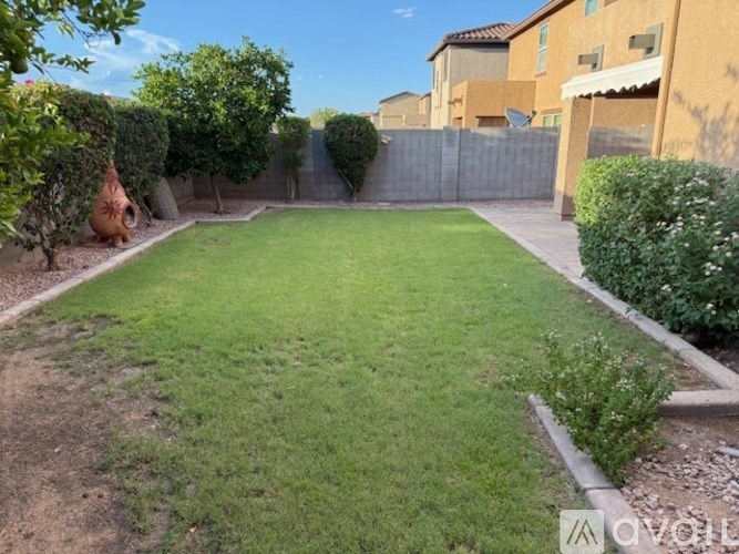 A backyard with a well-maintained lawn and a fence.