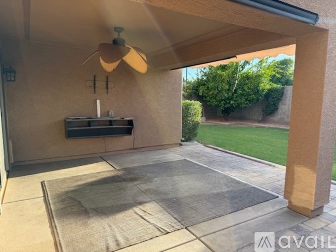 A patio area with a fan and a table.