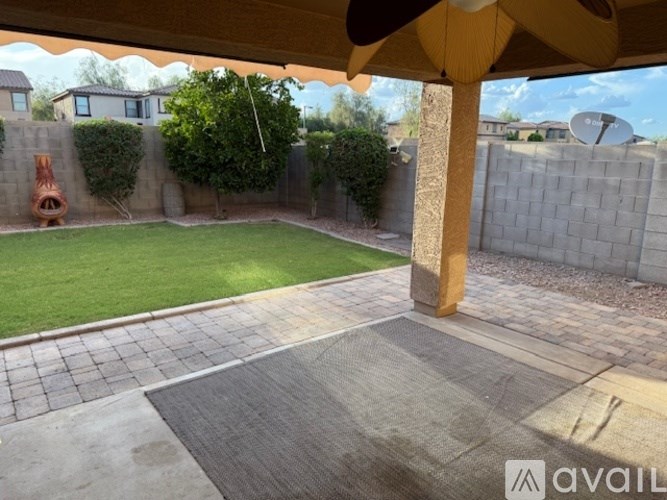 A patio area with a brick walkway and a stone pillar.