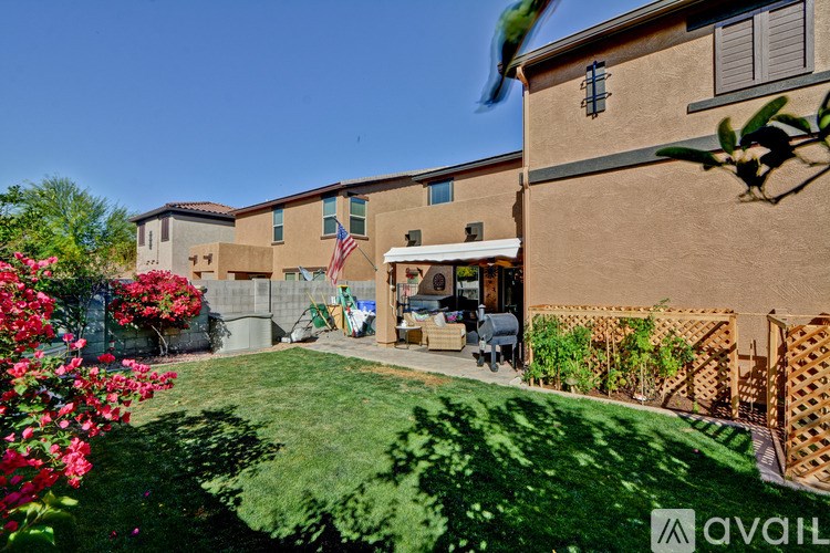 A sunny day at a house with a garden and a patio.