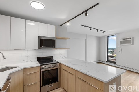 A kitchen with a white countertop and wooden cabinets.